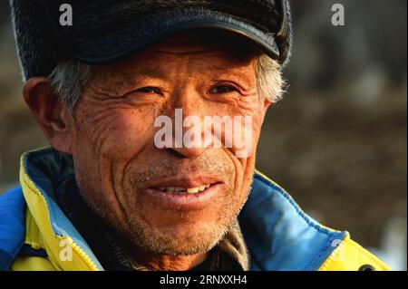 (180216) -- JINAN, 16. Februar 2018 -- Yuan Xueshun lächelt, als er Schwäne beim Essen in der Stadt Chengshan in der Stadt Rongcheng, Ostchinesische Provinz Shandong, am 14. Februar 2018 beobachtet. Yuan Xueshun, auch Schwanenwächter genannt, widmet sich seit über 40 Jahren dem Schutz von Schwänen. Er hat mehr als 1.000 kranke oder verwundete Schwäne gerettet und konnte seit 1975 verhindern, dass mehr als 1.000 mu (66,67 Hektar) Feuchtgebiet zerstört werden. Dank der Bemühungen von Menschen wie Yuan hat sich der Schwanensee in Rongcheng zu einem idealen Lebensraum für Schwäne im Winter entwickelt. ) (mp) CHINA-SHANDONG-SCHWANENSCHUTZ (CN) Fen Stockfoto