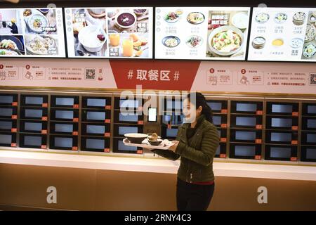 (180226) -- PEKING, 26. Februar 2018 -- Eine Kundin bekommt ihr Essen in einem vollautomatisierten Restaurant in Hangzhou, Ostchinas Provinz Zhejiang, 2. Februar 2018. Die jährlichen politischen Sitzungen des Nationalen Volkskongresses (NPC) und des Nationalen Komitees der Politischen Konsultativkonferenz des chinesischen Volkes (CPPCC) sollen im März 2018 stattfinden. In den beiden Sitzungen werden die Entwicklungsagenden überprüft und diskutiert und Schlüsselpolitiken verabschiedet. Das Jahr 2018 ist das erste Jahr der vollständigen Umsetzung des Geistes des 19. Nationalkongresses der Kommunistischen Partei Chinas. Stockfoto