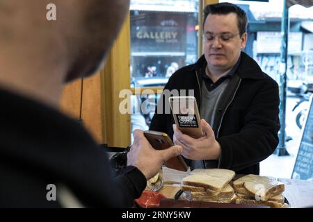 (180228) -- ATHEN, 28. Februar 2018 -- Ein Kunde nutzt sein Mobiltelefon, um in einem Café im Zentrum von Athen, Griechenland, am 25. Februar 2018 mit Bitcoin zu bezahlen. Griechenlands Bitcoin-Gemeinschaft wächst in den letzten Jahren, unterstützt durch die Kapitalkontrollen, die dem traditionellen Bankensystem seit dem Sommer 2015 auferlegt wurden, erklärten Nutzer und Investoren Xinhua, obwohl lokale Behörden vor den Risiken von Kryptowährungen warnen. ) Das Foto geht mit dem artikel Feature: Griechenlands Bitcoin-Community wächst unter Warnungen vor Kryptowährungsrisiken . GRIECHENLAND-ATHEN-BITCOIN LefterisxPartsalis PUBLICATIONxNOTxINxCHN Stockfoto