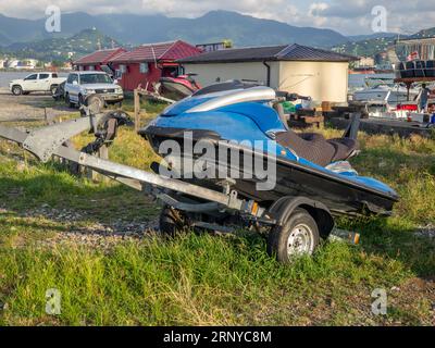 Gebrochener Jetski auf einem Anhänger. Verlassenes Fahrzeug. Wasserfahrrad am Ufer. Yachtparkplatz Stockfoto