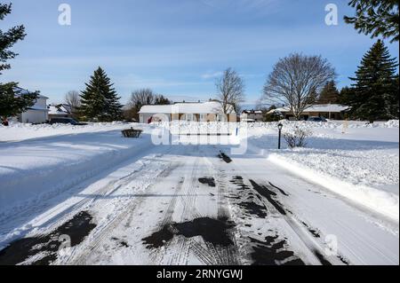 Nach dem Schneesturm ist eine lange Einfahrt geräumt. Stockfoto