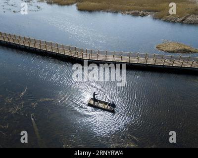 (180401) -- XIONGAN NEW AREA, 1. April 2018 -- auf diesem Luftbild vom 29. März 2018 reinigt ein Sanitäter den Baiyangdian-See in Xiongan New Area, nordchinesische Provinz Hebei. Xiongan New Area, gegründet am 1. April 2017, ist eine neue Wirtschaftszone etwa 100 Kilometer südwestlich von Peking. Es ist das dritte neue Gebiet von nationaler Bedeutung nach der Shenzhen Special Economic Zone und dem Shanghai Pudong New Area. China will es als eine kohlenstoffarme, intelligente, lebenswerte und global einflussreiche Stadt errichten, in der Menschen und Natur in Harmonie leben. ) (LMM) CHINA-XIONGAN NEW AREA-ANNIVER Stockfoto