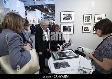 (180405) -- NEW YORK, 5. April 2018 -- ein Ausstellervertreter (C) zeigt den Besuchern auf der AIPAD (Association of International Photography Art Dealers), der Photography Show in New York, USA, am 5. April 2018. Die 38. Auflage der Photography Show findet vom 5. Bis 8. April statt. Rund 100 der weltweit führenden Kunstfotografen-Galerien präsentieren eine Reihe von Arbeiten in Museumsqualität, darunter zeitgenössische, moderne und Fotografien des 19. Jahrhunderts sowie fotobasierte Kunst, Video und neue Medien. ) U.S.-NEW YORK-AIPAD-DIE FOTOSHOW WANGXYING PUBLICATIONXN Stockfoto