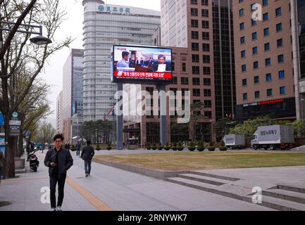 (180406) -- SEOUL, 6. April 2018 -- Menschen laufen an einem riesigen Bildschirm vorbei, der die Strafe an den angegriffenen Präsidenten Park Geun-hye in Seoul, Südkorea, 6. April 2018 überträgt. Ein südkoreanisches Gericht verurteilte am Freitag den Amtsenthebten Präsident Park Geun-hye zu 24 Jahren Haft mit einer Geldstrafe von 18 Milliarden Won (17 Millionen US-Dollar) wegen Korruption. (gj) SÜDKOREA-SEOUL-PARK GEUN-HYE WangxJingqiang PUBLICATIONxNOTxINxCHN Stockfoto