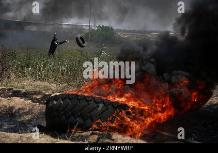 (180406) -- GAZA, 6. April 2018 -- Ein palästinensischer Demonstrant verbrennt bei Zusammenstößen an der Grenze zwischen Gaza und Israel östlich von Gaza-Stadt am 6. April 2018 Reifen. Hunderte palästinensischer Demonstranten begannen am Freitag, Dutzende von Autoreifen in der Nähe der Grenze zwischen dem östlichen Gazastreifen und Israel in Brand zu setzen, um einen Schild aus schwarzem Rauch zu machen, um sich vor dem Schuss israelischer Soldaten zu schützen. (zf) MIDEAST-GAZA-CLASHES Stringer PUBLICATIONxNOTxINxCHN Stockfoto