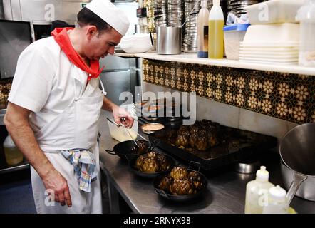 (180407) -- BARCELONA, 7. April 2018 -- Ein Koch bereitet Essen für Kunden in der Küche des Can Culleretes Restaurant in Barcelona, Spanien, 6. April 2018. Das im Jahr 1786 gegründete Restaurant Can Culleretes ist das älteste Restaurant in Spaniens berühmter Touristenstadt Barcelona. Es serviert traditionelle katalanische Küche, die in den letzten sechs Jahrzehnten von drei Generationen derselben Familie betrieben wurde. ) (psw) SPANIEN-BARCELONA-CAN CULLERETES RESTAURANT GuoxQiuda PUBLICATIONxNOTxINxCHN Stockfoto