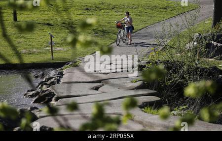 (180419) -- BRÜSSEL, 19. April 2018 -- Eine Frau spaziert in einem Park in Brüssel, Belgien, 19. April 2018. Die Temperatur stieg hier am Donnerstag auf etwa 28 Grad Celsius, was den heißesten April seit Wetterrekorden darstellt. ) BELGIEN-BRÜSSEL-FRÜHLING YexPingfan PUBLICATIONxNOTxINxCHN Stockfoto