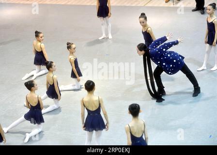 (180510) -- PEKING, 10. Mai 2018 -- Feng Ying, Direktor des chinesischen Nationalballetts, demonstriert jungen Tänzern während einer Probe des neunfarbigen Hirsches in der Pekinger Jinsong-Grundschule Nr. 4 in Peking, Hauptstadt Chinas, 10. Mai 2018. Der neunfarbige Hirsch ist ein Ballett des National Ballet of China, das auf einem Volksmund basiert. Die Geschichte handelt von einem königlichen Hirsch, der an den Wänden der Dunhuang Mogao Grotten an einer kulturellen und religiösen Kreuzung auf der alten Seidenstraße in der nordwestlichen chinesischen Provinz Gansu liegt. (LB) CHINA-BEIJING-BALLETT-GRUNDSCHULE (CN) JINXLIANGKUAI PUBLICAT Stockfoto