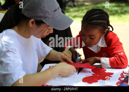 (180512) -- MAPUTO, 12. Mai 2018 -- Ein mosambikanisches Kind lernt beim ersten chinesischen Neujahrskarneval in Maputo, Mosambik, am 10. Februar 2018 das chinesische Papercutting. Da die Beziehungen zwischen China und Mosambik aufgrund der traditionellen Freundschaft weiter aufheizen, nimmt die Kommunikation zwischen den Menschen der beiden Länder im kulturellen Bereich von Tag zu Tag zu. Immer mehr Mosambikaner haben ihr Verständnis von China und der traditionellen und modernen chinesischen Kultur vertieft. ) (dtf) MOSAMBIK-CHINA-KULTURAUSTAUSCH NiexZuguo PUBLICATIONxNOTxINxCHN Stockfoto