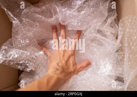 Legen Sie die Luftpolsterfolie in einen Karton Stockfoto