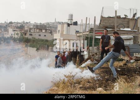 (180525) -- BETHLEHEM, 25. Mai 2018 -- einer der Palästinenser, der versuchte, Israels umstrittene Barriere zu besteigen, um vom Westjordanland nach Jerusalem zu gelangen, und der von israelischen Sicherheitskräften verboten wurde, tritt eine von israelischen Sicherheitskräften gefeuerte Tränengasgranate, Sie machen sich auf den Weg zum zweiten Ramadan-Freitagsgebet in Jerusalems al-Aqsa-Moschee, in der Nähe der Westjordstadt Bethlehem, am 25. Mai 2018. ) (Zjl) MIDEAST-BETHLEHEM-FRIDAY-PRAYERS LuayxSababa PUBLICATIONxNOTxINxCHN Stockfoto