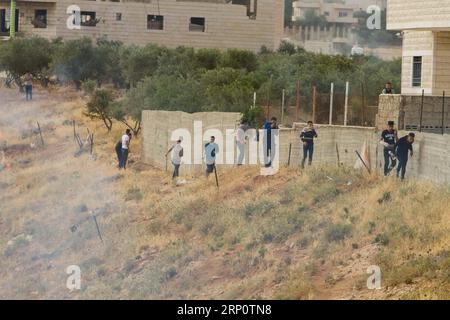 (180525) -- BETHLEHEM, 25. Mai 2018 -- Palästinenser, die versuchten, Israels umstrittene Barriere zu besteigen, um vom Westjordanland nach Jerusalem zu gelangen, und die von israelischen Sicherheitskräften verboten wurden, liefen in Deckung, um Tränengas von israelischen Sicherheitskräften abzufangen, Sie machen sich auf den Weg zum zweiten Ramadan-Freitagsgebet in Jerusalems al-Aqsa-Moschee, in der Nähe der Westjordstadt Bethlehem, am 25. Mai 2018. ) (Zjl) MIDEAST-BETHLEHEM-FRIDAY-PRAYERS LuayxSababa PUBLICATIONxNOTxINxCHN Stockfoto