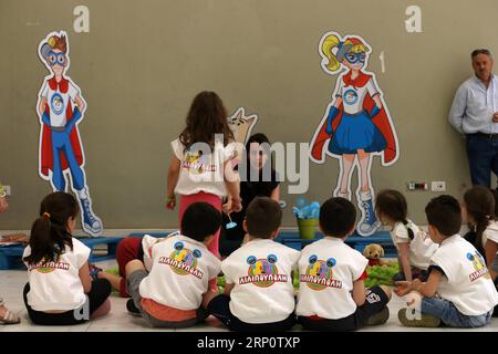 (180525) -- ATHEN, 25. Mai 2018 -- Eine Frau erzählt Kindern Märchen während einer Veranstaltung zum Internationalen Tag der vermissten Kinder, in Athen, Griechenland, am 25. Mai 2018. Griechenland hat am Freitag den Internationalen Tag der vermissten Kinder mit einer Konferenz gefeiert, auf der Beamte und Experten ermutigende Statistiken vorstellten. ) GRIECHENLAND-ATHEN-INTERNATIONALER TAG DER VERMISSTEN KINDER MARIOSXLOLOS PUBLICATIONXNOTXINXCHN Stockfoto