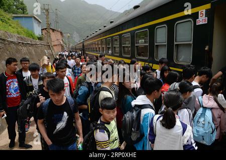 (180529) -- XI AN, 29. Mai 2018 -- Studenten gehen in den Zug am Baishuijiang Bahnhof in der nordwestchinesischen Provinz Guansu, 27. Mai 2018. Der Zug Nr. 6063, der 38 Stationen entlang der Strecke von Baoji der Provinz Shaanxi und Guangyuan der Provinz Sichuan verbindet, bedient Tausende von Schülern, die in Bergregionen leben und jede Woche von Schulen nach Hause pendeln müssen. Zur Verbesserung der Leistungen für die Schülerpassagiere wurden Ende 2017 Sonderwagen mit größeren Schreibtischen und einer Bibliothek in Betrieb genommen. Mit dem Beginn des diesjährigen Internationalen Kindertages, ov Stockfoto