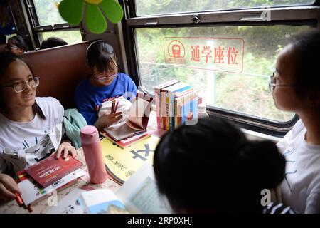 (180529) -- XI AN, 29. Mai 2018 -- Studenten lesen neue Bücher in den Sonderwagen der Studenten im Zug Nr. 6063 in China, 27. Mai 2018. Der Zug Nr. 6063, der 38 Stationen entlang der Strecke von Baoji der Provinz Shaanxi und Guangyuan der Provinz Sichuan verbindet, bedient Tausende von Schülern, die in Bergregionen leben und jede Woche von Schulen nach Hause pendeln müssen. Zur Verbesserung der Leistungen für die Schülerpassagiere wurden Ende 2017 Sonderwagen mit größeren Schreibtischen und einer Bibliothek in Betrieb genommen. Mit dem Beginn des diesjährigen Internationalen Kindertags, über 300 neue Stockfoto