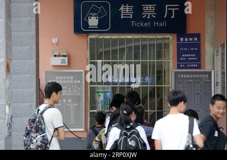 (180529) -- XI AN, 29. Mai 2018 -- Studenten stehen am 27. Mai 2018 am Bahnhof Baishuijiang in der nordwestchinesischen Provinz Guansu AN, um Tickets zu kaufen. Der Zug Nr. 6063, der 38 Stationen entlang der Strecke von Baoji der Provinz Shaanxi und Guangyuan der Provinz Sichuan verbindet, bedient Tausende von Schülern, die in Bergregionen leben und jede Woche von Schulen nach Hause pendeln müssen. Zur Verbesserung der Leistungen für die Schülerpassagiere wurden Ende 2017 Sonderwagen mit größeren Schreibtischen und einer Bibliothek in Betrieb genommen. Mit dem Ansatz der diesjährigen International Children s Stockfoto