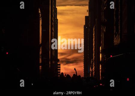 (180531) -- NEW YORK, 31. Mai 2018 -- Menschen fotografieren Manhattanhenge in New York, USA, 30. Mai 2018. Das Manhattanhenge bezieht sich auf den zweimal im Jahr stattfindenden Umstand, dass die untergehende Sonne genau auf die Ost-West-Straßen des New Yorker Stadtbezirks Manhattan ausgerichtet ist. (Zxj) U.S.-NEW YORK-MANHATTANHENGE LixMuzi PUBLICATIONxNOTxINxCHN Stockfoto