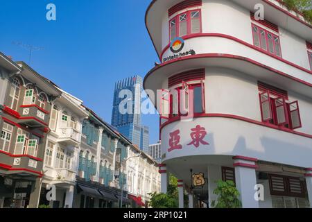 Das Gebäude im Art déco-Stil des Potato Head Restaurant (r) in der Keong Saik Rd, Singapur, und (l) bunt renovierte alte Shophouses in der Teck Lim Road Stockfoto