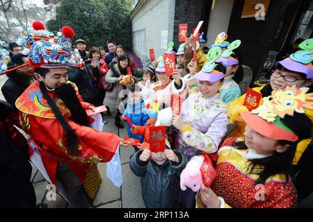 (180602) -- PEKING, 2. Juni 2018 -- Aktenfoto vom 10. Februar 2013 zeigt Kinder, die glückliche rote Pakete von einem Mann erhalten, der als Gott des Reichtums gekleidet ist, um das chinesische Mondneujahr in Yangzhou, der ostchinesischen Provinz Jiangsu, zu feiern. Dieses Set aus 41 alten Fotos, die von 1978 bis 2018 pro Jahr aufgenommen wurden, zeichnet die Kindheitsmomente chinesischer Kinder in den letzten vier Jahrzehnten bildhaft auf.) (wyo)(zt) CHINA-OLD PHOTOS-CHILDHOOD-PICTORIAL RECORD (CN) ZhuxXudong PUBLICATIONxNOTxINxCHN Stockfoto