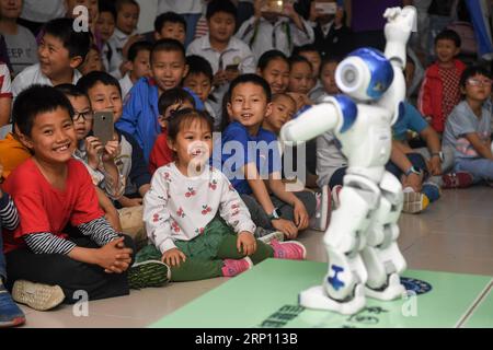 (180602) -- PEKING, 2. Juni 2018 -- Aktenfoto vom 19. Mai 2018 zeigt Kinder, die eine Roboterleistung während einer wissenschaftlichen Aktivität in Hefei, der ostchinesischen Provinz Anhui, beobachten. Dieses Set von 41 alten Fotos, die von 1978 bis 2018 pro Jahr aufgenommen wurden, zeichnet die Kindheitsmomente chinesischer Kinder in den letzten vier Jahrzehnten bildhaft auf. ) (wyo)(zt) CHINA-OLD PHOTOS-CHILDHOOD-PICTORIAL RECORD (CN) ZhangxDuan PUBLICATIONxNOTxINxCHN Stockfoto