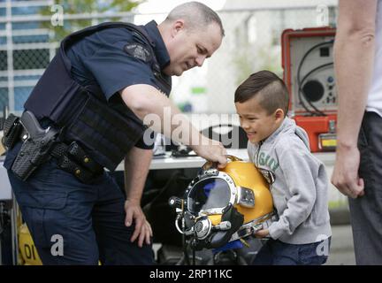 (180603) -- RICHMOND, 3. Juni 2018 -- Ein Kind versucht, einen Helm bei der Hauptabteilung der Royal Canadian Mounted Police während der jährlichen Open Doors-Veranstaltung in Richmond, Kanada, am 3. Juni 2018 anzuheben. Die jährlich stattfindende Open Doors-Veranstaltung bietet den Bürgern freien Zugang zu Dutzenden von Sehenswürdigkeiten in der Stadt, um mehr über das Erbe und die Tätigkeit in der Gemeinde zu erfahren. ) KANADA-RICHMOND-OPEN DOORS EVENT LiangxSen PUBLICATIONxNOTxINxCHN Stockfoto