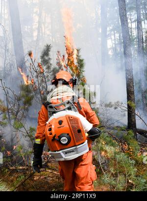 (180604) -- GENHE, 4. Juni 2018 -- Ein Feuerwehrmann löscht Feuer an einer Brandstelle im Hanma National Nature Reserve der Autonomen Region Innere Mongolei in Nordchina, 4. Juni 2018. Ein Waldbrand, der in der Autonomen Region Innere Mongolei ausbrach, hat sich auf die benachbarte Provinz Heilongjiang ausgebreitet, sagten die lokalen Feuerwehren am Montag. Mehr als 3.600 Feuerwehrleute, Forstpolizisten und große Feuerlöschgeräte wurden mobilisiert. ) LB) CHINA-INNER MONGOLIA-FOREST FIRE (CN) LiuxLei PUBLICATIONxNOTxINxCHN Stockfoto