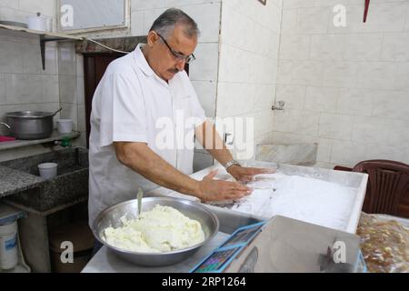 (180605) -- TRIPOLI, 5. Juni 2018 -- Ein Koch macht Al-Shmisa süß in Tripoli, Libanon, 4. Juni 2018. Al-Shmisa-Süßes oder Creme-Donut ist eine der beliebtesten Süßwaren, die nur im libanesischen Tripoli zu finden sind. Diese Art von Süßes wird nur von der Familie al-Haddad hergestellt, deren Söhne diesen Beruf jahrzehntelang erbten. ) (lrz) LEBANON-TRIPOLI-CREAM DONUT Khalid PUBLICATIONxNOTxINxCHN Stockfoto