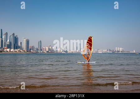 (180606) -- QINGDAO, 6. Juni 2018 -- Ein Mann geht Windsurfer in Qingdao, ostchinesische Provinz Shandong, 4. Mai 2018. Der 18. Gipfel der Shanghai Cooperation Organization (SCO) ist für den 9. Bis 10. Juni in Qingdao vorgesehen. )(mcg) CHINA-QINGDAO-DAILY LIFE (CN) ZhangxCheng PUBLICATIONxNOTxINxCHN Stockfoto