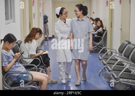 (180612) -- FUZHOU, 12. Juni 2018 -- Eine Krankenschwester führt eine schwangere Frau, die die Reservierung für die regelmäßige Überprüfung auf dem Handy im Fujian Provincial Maternity and Children s Hospital in Fuzhou, Hauptstadt der südöstlichen Provinz Fujian, gemacht hat, 12. Juni 2018. Das Fujian Provincial Maternity and Children s Hospital hat die Einrichtungen und Dienstleistungen in den letzten Jahren verbessert. Es wurde ein neues Gebäude errichtet und Spitzentechnologie eingesetzt. Patienten können Dokumente ablegen, Anweisungen vor der Entbindung erhalten und Massagen für Neugeborene über Mobiltelefone reservieren. )(WSW) CHINA-FUJIAN-HOSPITAL-SERVICE IMPROVISATION Stockfoto