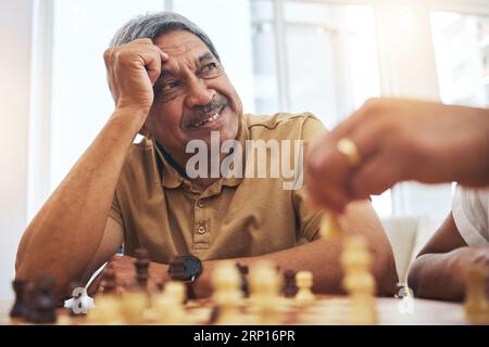 Senior man, zu Hause und Schach für Wettbewerb, Spiel und Strategie mit Freund für Konzentration und Entspannung im Wohnzimmer. Denken, Senioren und Menschen mit Pension Stockfoto