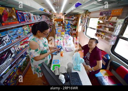 (180613) -- XI AN, 13. Juni 2018 -- Ein Bewohner kauft Waren in einem stillgelegten Zugwagen, der als kleiner Supermarkt in einer Wohnsiedlung in Xi an, Hauptstadt der nordwestchinesischen Provinz Shaanxi, 13. Juni 2018 diente. ) (Zwx) CHINA-XI AN-TRAIN CONVERTED SUPERMARKET (CN) ShaoxRui PUBLICATIONxNOTxINxCHN Stockfoto