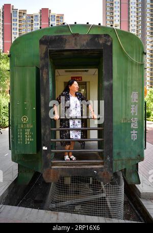 (180613) -- XI AN, 13. Juni 2018 -- Ein Ladenbesitzer steht auf einem stillgelegten Zugwagen und diente als kleiner Supermarkt in einer Wohnsiedlung in Xi an, Hauptstadt der nordwestchinesischen Provinz Shaanxi, 13. Juni 2018. ) (Zwx) CHINA-XI AN-TRAIN CONVERTED SUPERMARKET (CN) ShaoxRui PUBLICATIONxNOTxINxCHN Stockfoto