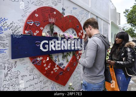 (180614) -- LONDON, 14. Juni 2018 -- Menschen hinterlassen Blumen und Tribut an einer Gedenkmauer am Fuß des Grenfell Tower in Ladbroke Grove,?West London,?Großbritannien, 14. Juni 2018. Mehr als 200 Überlebende wurden am Donnerstag in den Grenfell Tower in London zurückgelassen, um ihnen zu helfen, das Ausmaß der Katastrophe zu verstehen, da die britische Hauptstadt den ersten Jahrestag des tödlichen Feuers markierte. Insgesamt sind 223 Menschen vor einem Jahr der Flamme entkommen, während 72 getötet wurden. ) GROSSBRITANNIEN-LONDON-GRENFELL?TOWER-FIRE-ONE YEAR TODAY STEPHENXCHUNG PUBLICATIONXNOTXINXCHN Stockfoto