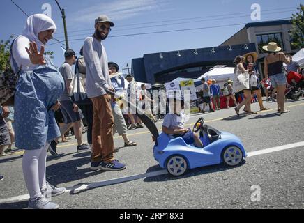 (180618) -- VANCOUVER, 18. Juni 2018 -- Ein Kind reitet auf seinem autoförmigen Kinderwagen auf der geschlossenen Straße während des Car Free Day Events in Vancouver, Kanada, 17. Juni 2018. Der Car Free Day ist eine jährliche Veranstaltung zur Förderung eines kohlenstoffarmen Lebensstils und des gesellschaftlichen Engagements. Mehr als 20 Straßenblöcke wurden für den Autoverkehr gesperrt, der die Menschen zu verschiedenen Aktivitäten anlockte. )(gj) CANADA-VANCOUVER-CAR FREE DAY LiangxSen PUBLICATIONxNOTxINxCHN Stockfoto