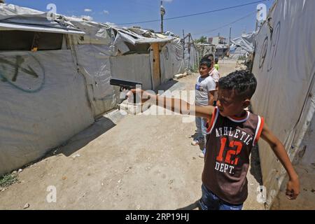 180619 -- BEIRUT, 19. Juni 2018 -- Ein Flüchtlingskind hält am 19. Juni 2018 eine Spielzeugpistole in einem syrischen Flüchtlingslager in Bar Elias, Bekaa Valley, Ostlibanon. vor dem Welttag der Flüchtlinge. Nach Jahren des Krieges in Syrien setzten syrische Flüchtlinge ihr Leben im Libanon fort. Die Zahl der Menschen, die aufgrund von Kriegen, anderer Gewalt und Verfolgung gewaltsam vertrieben wurden, erreichte 2017 weltweit einen neuen Höchststand auf 68,5 Millionen, 2,9 Millionen mehr als im Vorjahr, sagte die UN-Flüchtlingsagentur UNHCR am Dienstag. LIBANON-BEKAA-TAL-BAR ELIAS-SYRISCHES FLÜCHTLINGSCAMP BILALXJAWICH PUBLICATIONXNOTXINXCHN Stockfoto