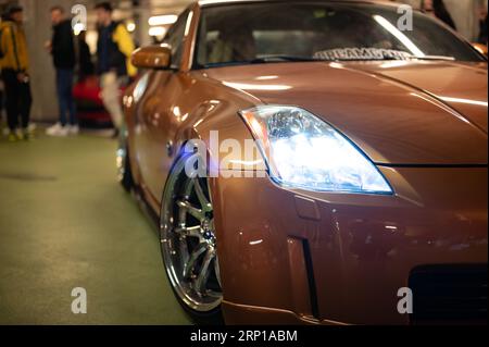 Ein ikonischer Nissan 350Z in oranger Farbe, in einer Konzentration von japanischem Tuning Stockfoto