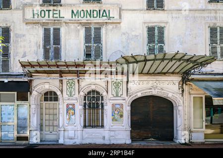 Menton, Frankreich - 26. Mai 2023: Keramik im Jugendstil des ehemaligen Hotels Mondial, eine verzierte Gebäudefassade, die heute aufgegeben und veraltet ist Stockfoto