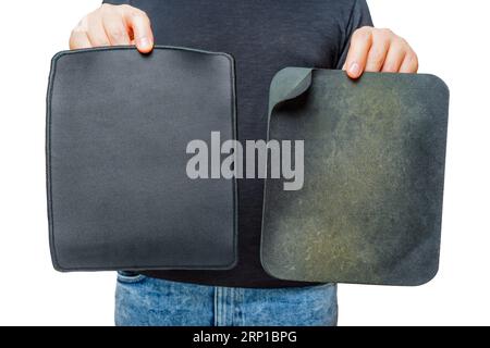 Die Person demonstriert ein brandneues, sauberes Mauspad in der Nähe eines gut gebrauchten und getragenen Mauspads isoliert auf weiß. Stockfoto