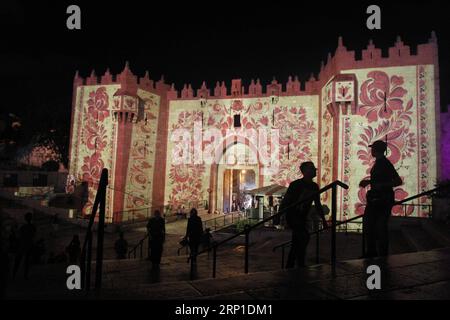 (180628) -- JERUSALEM, 28. Juni 2018 -- Menschen sehen Bilder, die auf das Damaskustor der Altstadt von Jerusalem während des Jerusalem-Lichtfestivals 2018 am 28. Juni 2018 projiziert werden. ) MIDEAST-JERUSALEM-OLD CITY-LIGHT FESTIVAL MUAMMARXAWAD PUBLICATIONXNOTXINXCHN Stockfoto
