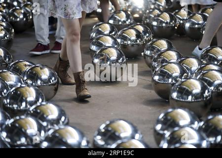 (180629) -- NEW YORK, 29. Juni 2018 -- die Leute besuchen eine Medienvorschau von Yayoi Kusamas ortsspezifischer Installation von Narcissus Garden im Gateway National Recreation Area in Fort Tilden, New York, USA, 29. Juni 2018. Der Narcissus Garden von Yayoi Kusama, der aus 1.500 Spiegelkugeln aus Edelstahl besteht, wird ab dem 1. Juli auf einem ehemaligen US-Militärstützpunkt in New York für die Öffentlichkeit zugänglich sein. ) U.S.-NEW YORK-YAYOI KUSAMA-INSTALLATION ART-NARCISSUS GARDEN WANGXYING PUBLICATIONXNOTXINXCHN Stockfoto