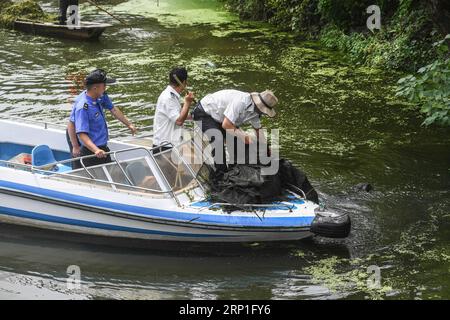 (180704) -- HUZHOU, 4. Juli 2018 -- Arbeiter demontieren einen Netzkäfig in einem Fluss in Doling Stadt Huzhou, Ostchinesische Provinz Zhejiang, 3. Juli 2018. Die Stadt hat vor kurzem ein Projekt zur Reinigung von Flüssen gestartet, um im Sommer sauberes Wasser und einen reibungslosen Lauf der ländlichen Flüsse zu gewährleisten.) (Sxk) CHINA-ZHEJIANG-HUZHOU-RURAL ENVIRONMENT (CN) XuxYu PUBLICATIONxNOTxINxCHN Stockfoto