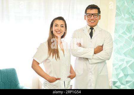 Ärzte, die die Kamera mit Stolz in der Klinik betrachten Stockfoto