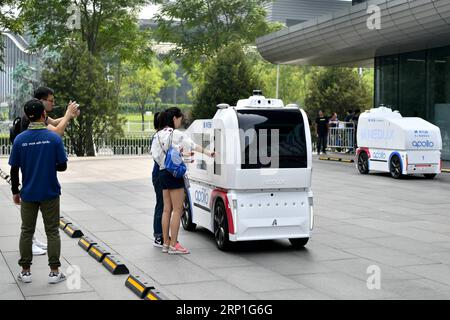 (180704) -- PEKING, 4. Juli 2018 -- Menschen interagieren mit einem selbstfahrenden Logistikwagen während Baidu Create 2018 im China National Convention Center in Peking, Hauptstadt von China, 4. Juli 2018. Baidu Create 2018, die jährliche KI-Entwicklerkonferenz des chinesischen Tech-Giganten, die auf der Nasdaq-Liste steht, wurde hier am Mittwoch eröffnet. ) LB) CHINA-BEIJING-BAIDU-AI-CONFERENCE (CN) LixXin PUBLICATIONxNOTxINxCHN Stockfoto