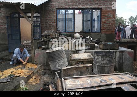 (180710) -- SRINAGAR, 10. Juli 2018 -- A Kashmiri sammelt beschädigten Reis in einem Haus, das bei einer Schießerei im Dorf Kundalan im Bezirk Shopian, etwa 60 km südlich von Srinagar, der Sommerhauptstadt des von Indien kontrollierten Kaschmirs, am 10. Juli 2018 beschädigt wurde. Zwei Militante und ein Zivilist wurden am Dienstag in einem heftigen bewaffneten Kampf und den darauf folgenden Zusammenstößen im von Indien kontrollierten Kaschmir getötet.) (lrz) INDIEN-KASCHMIR-SRINAGAR-GUNFIGHT JavedxDar PUBLICATIONxNOTxINxCHN Stockfoto