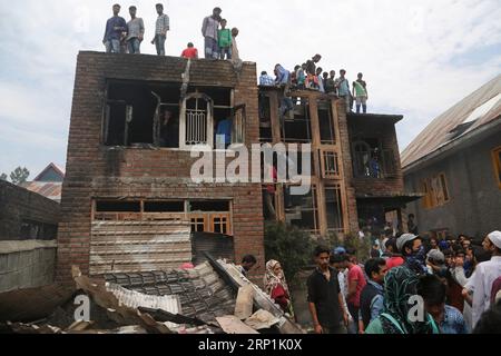 (180710) -- SRINAGAR, 10. Juli 2018 -- Kaschmirbewohner versammeln sich in einem Haus, das bei einem Schusswechsel im Dorf Kundalan im Bezirk Shopian, etwa 60 km südlich von Srinagar, der Sommerhauptstadt des von Indien kontrollierten Kaschmirs, am 10. Juli 2018 beschädigt wurde. Zwei Militante und ein Zivilist wurden am Dienstag in einem heftigen bewaffneten Kampf und den darauf folgenden Zusammenstößen im von Indien kontrollierten Kaschmir getötet. (lrz) INDIEN-KASCHMIR-SRINAGAR-GUNFIGHT JavedxDar PUBLICATIONxNOTxINxCHN Stockfoto