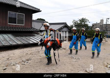 (180711) -- HIROSHIMA, 11. Juli 2018 -- Rettungskräfte gehen an einem überfluteten Haus in Kure, Hiroshima, Südwest-Japan, 11. Juli 2018 vorbei. Die Zahl der Todesopfer nach sintflutartigen Regenfällen, die Westjapan heimsuchten und verheerende Überschwemmungen und tödliche Erdrutsche verursachten, erreichte am Mittwoch 176, sagten die Behörden. )(yg) JAPAN-HIROSHIMA-WETTER MaxPing PUBLICATIONxNOTxINxCHN Stockfoto