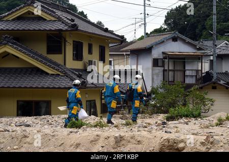 (180711) -- HIROSHIMA, 11. Juli 2018 -- Polizisten gehen an einem überfluteten Haus in Kure, Hiroshima, Südwest-Japan, 11. Juli 2018 vorbei. Die Zahl der Todesopfer nach sintflutartigen Regenfällen, die Westjapan heimsuchten und verheerende Überschwemmungen und tödliche Erdrutsche verursachten, erreichte am Mittwoch 176, sagten die Behörden. )(yg) JAPAN-HIROSHIMA-WETTER MaxPing PUBLICATIONxNOTxINxCHN Stockfoto