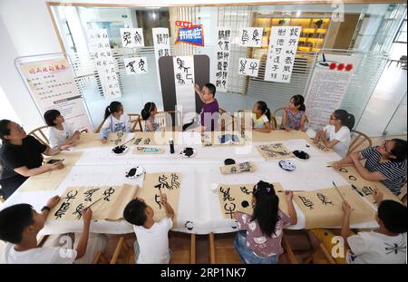 (180716) -- QINGDAO, 16. Juli 2018 -- Schüler lernen traditionelle chinesische Kalligraphie in der Gucheng Community in Qingdao, Ostchinesische Provinz Shandong, 16. Juli 2018. Die Studenten verbrachten ihren Sommerurlaub damit, traditionelle chinesische Kunst zu studieren. (wyl) CHINA-SHANDONG-QINGDAO-SOMMERURLAUB (CN) LiangxXiaopeng PUBLICATIONxNOTxINxCHN Stockfoto