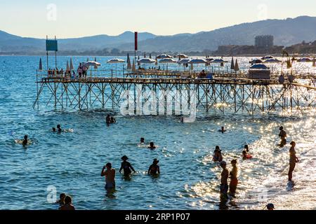 Cannes, Frankreich - 31. Juli 2022: Touristen sonnen sich am Strand Plage du Midi am Mittelmeerküsten der französischen Riviera Azure Stockfoto