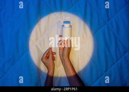 Schlafkapsel, Hand in Mondschein auf einer Decke, Melatonins Kampf gegen Schlaflosigkeit Stockfoto